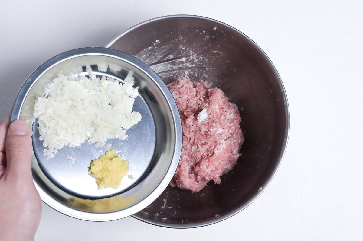 adding finely diced onion and grated ginger to ground pork to make teriyaki meatballs