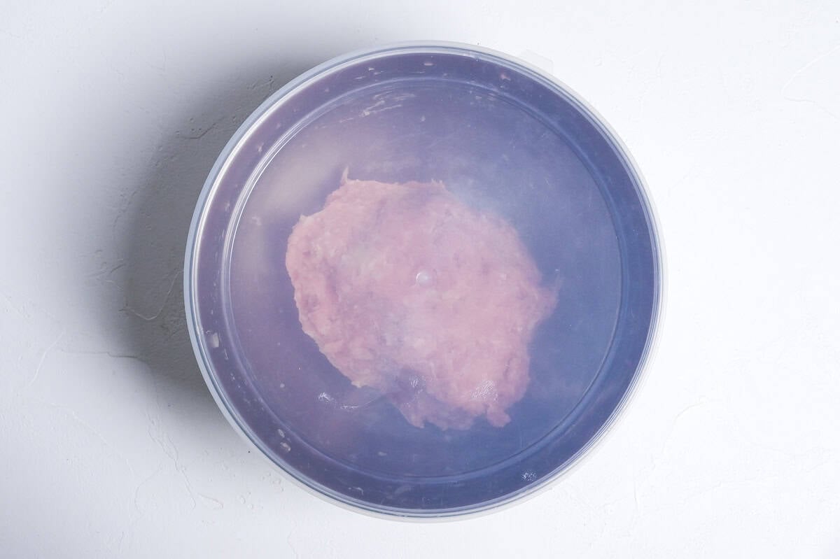 resting teriyaki meatball mixture in a steel mixing bowl with silicone lid