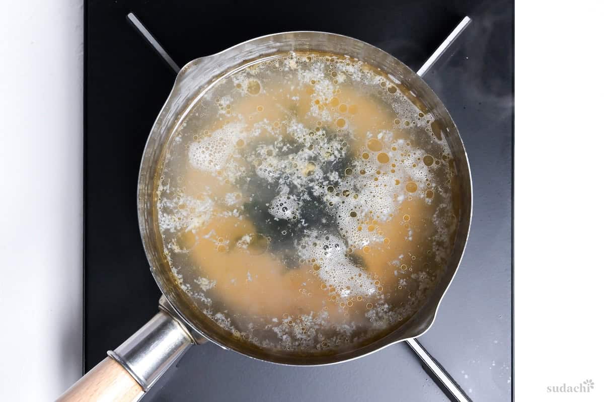 simmering wakame soup broth with wakame in a pan on the stove top