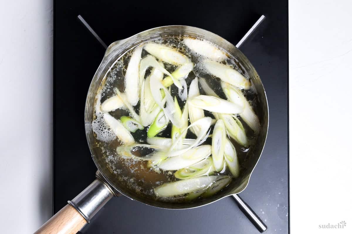 wakame soup with sliced Japanese leek in a pot on the stove top