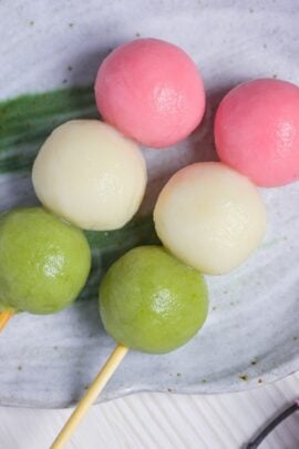 Two homemade tofu hanami dango on a gray plate with green brush design