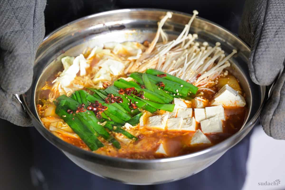Yuto Omura holding up Kimchi Nabe hot pot
