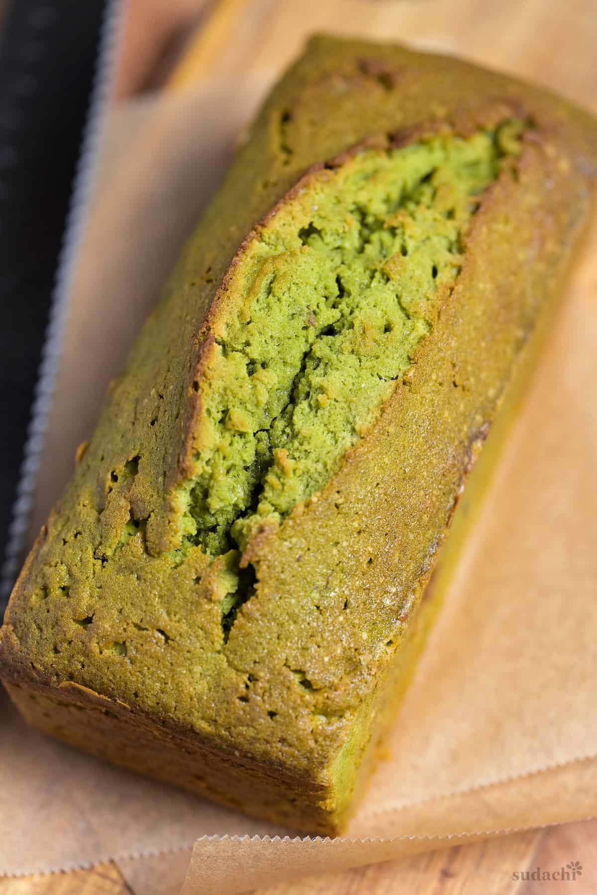 A whole matcha and adzuki pound cake on a wooden cutting board