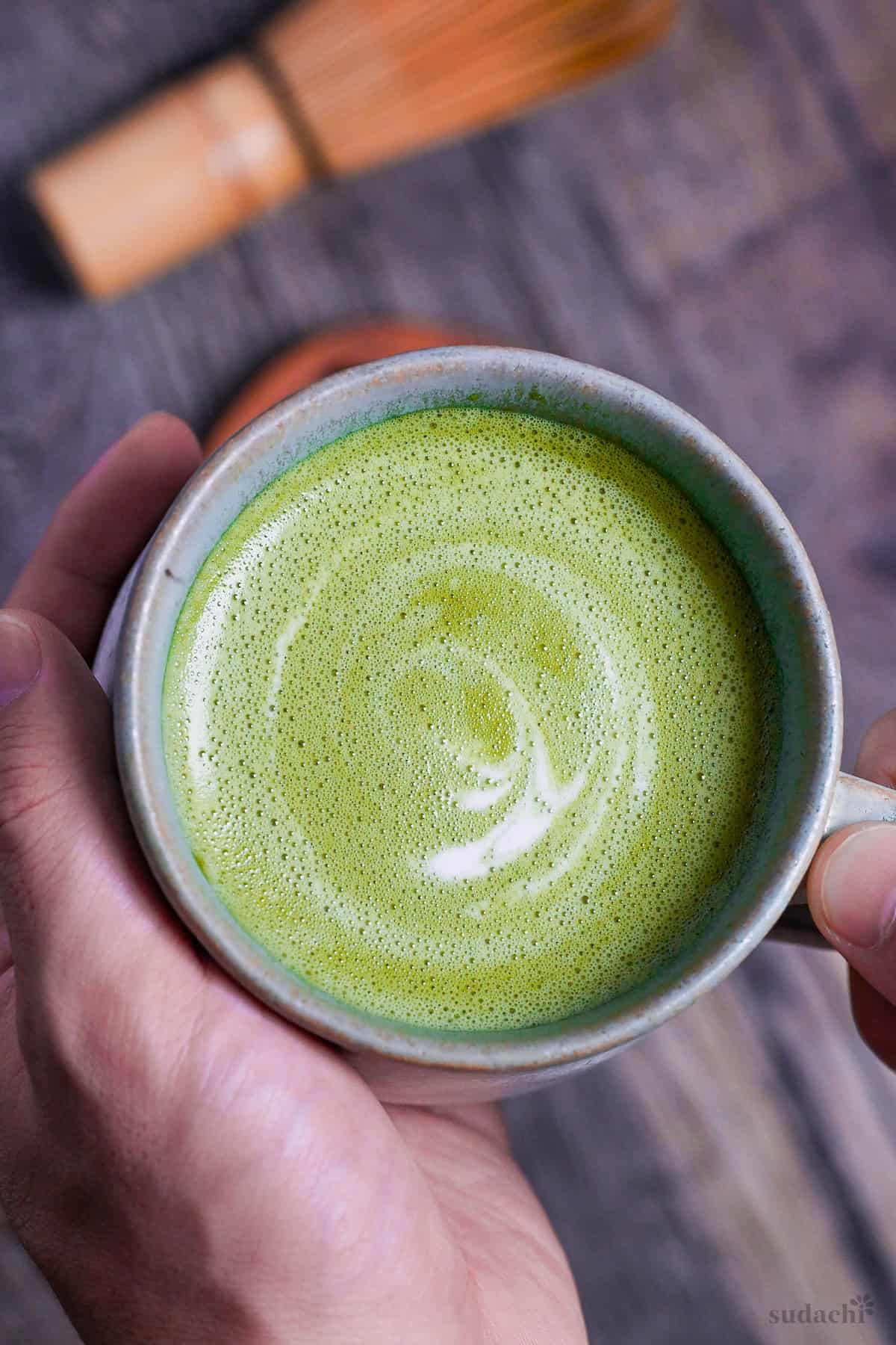 Cafe-style hot matcha latte in a teal ceramic cup