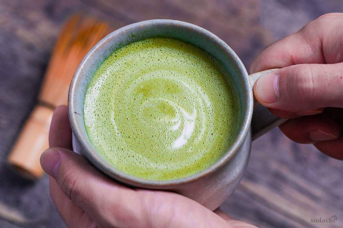 Cafe-style hot matcha latte in a teal ceramic cup