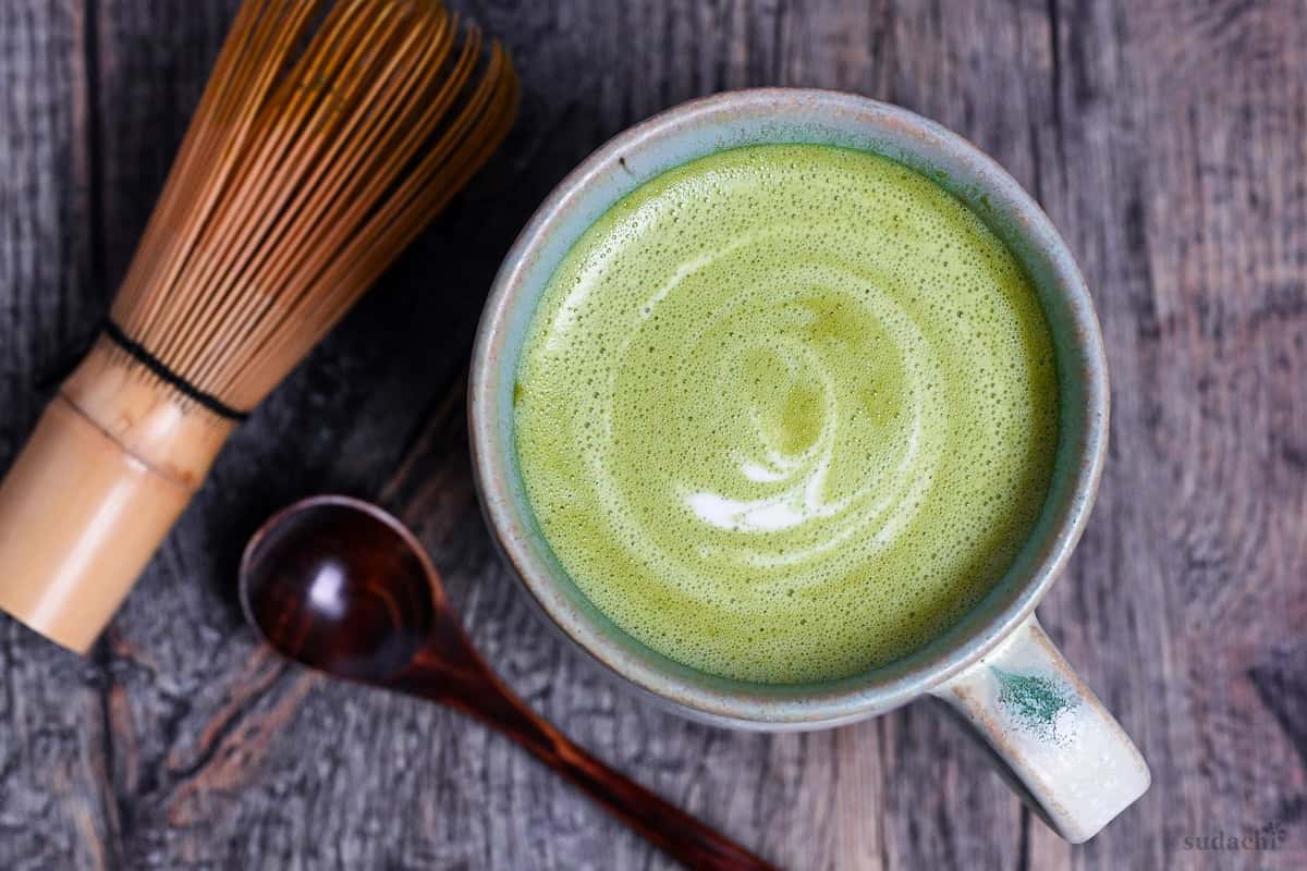 Cafe-style hot matcha latte in a teal ceramic cup