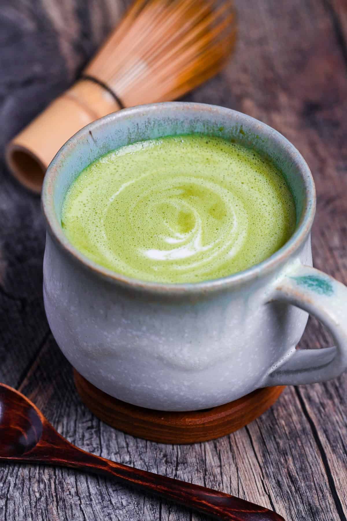 Cafe-style hot matcha latte in a teal ceramic cup