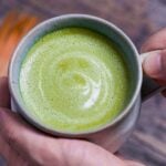 Cafe-style hot matcha latte in a teal ceramic cup