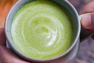 Cafe-style hot matcha latte in a teal ceramic cup