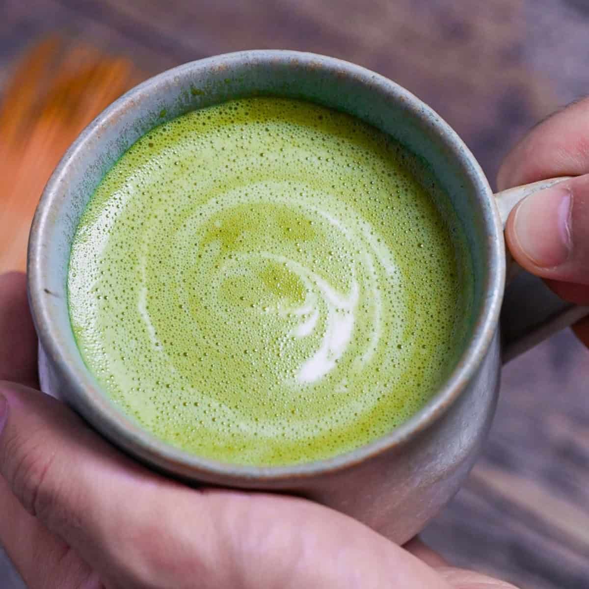 Cafe-style hot matcha latte in a teal ceramic cup