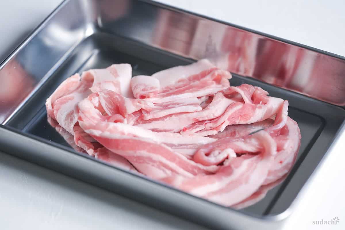 thinly sliced pork belly for shabu shabu in a steel rectangular container