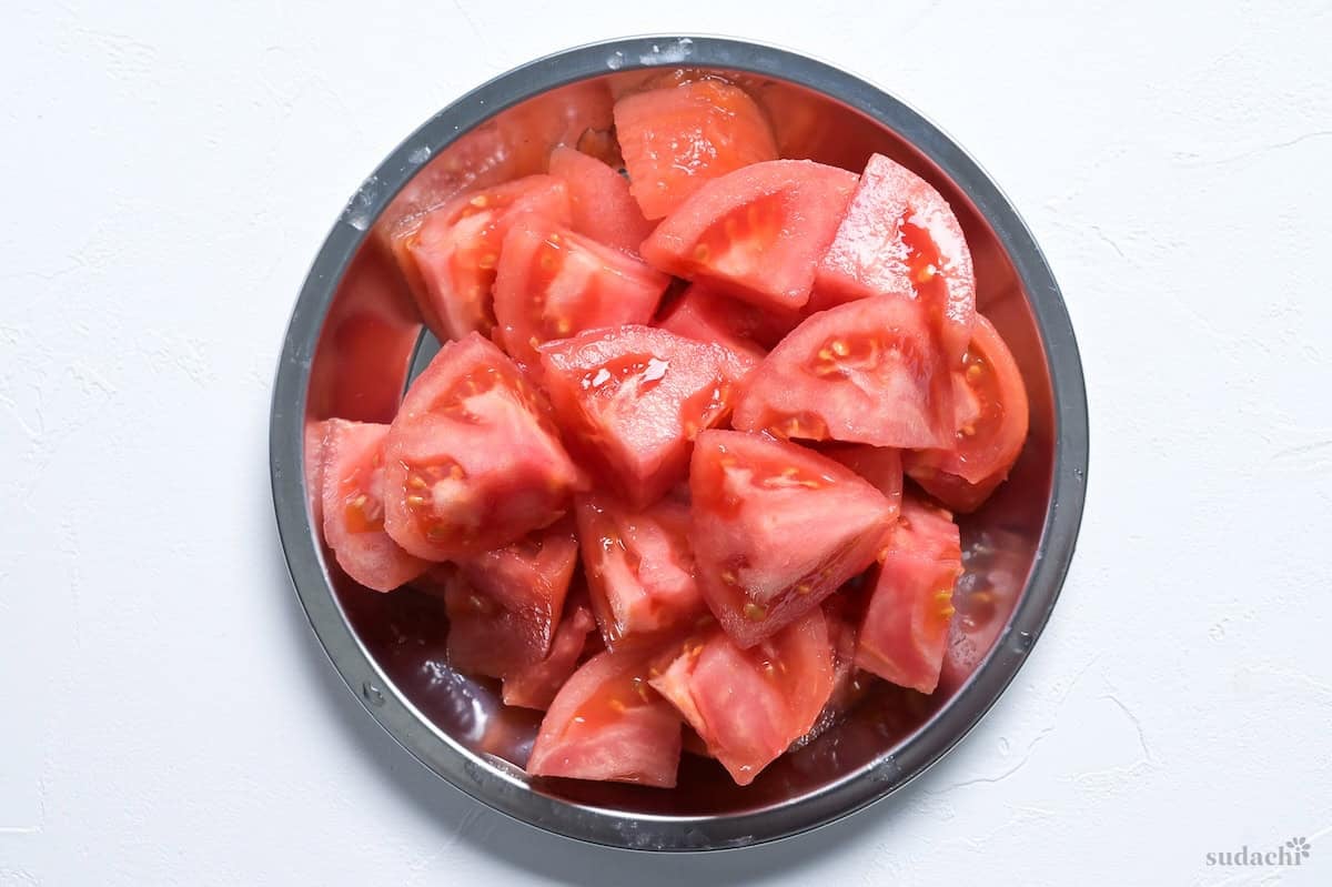 Cut tomato on a steel prep plate