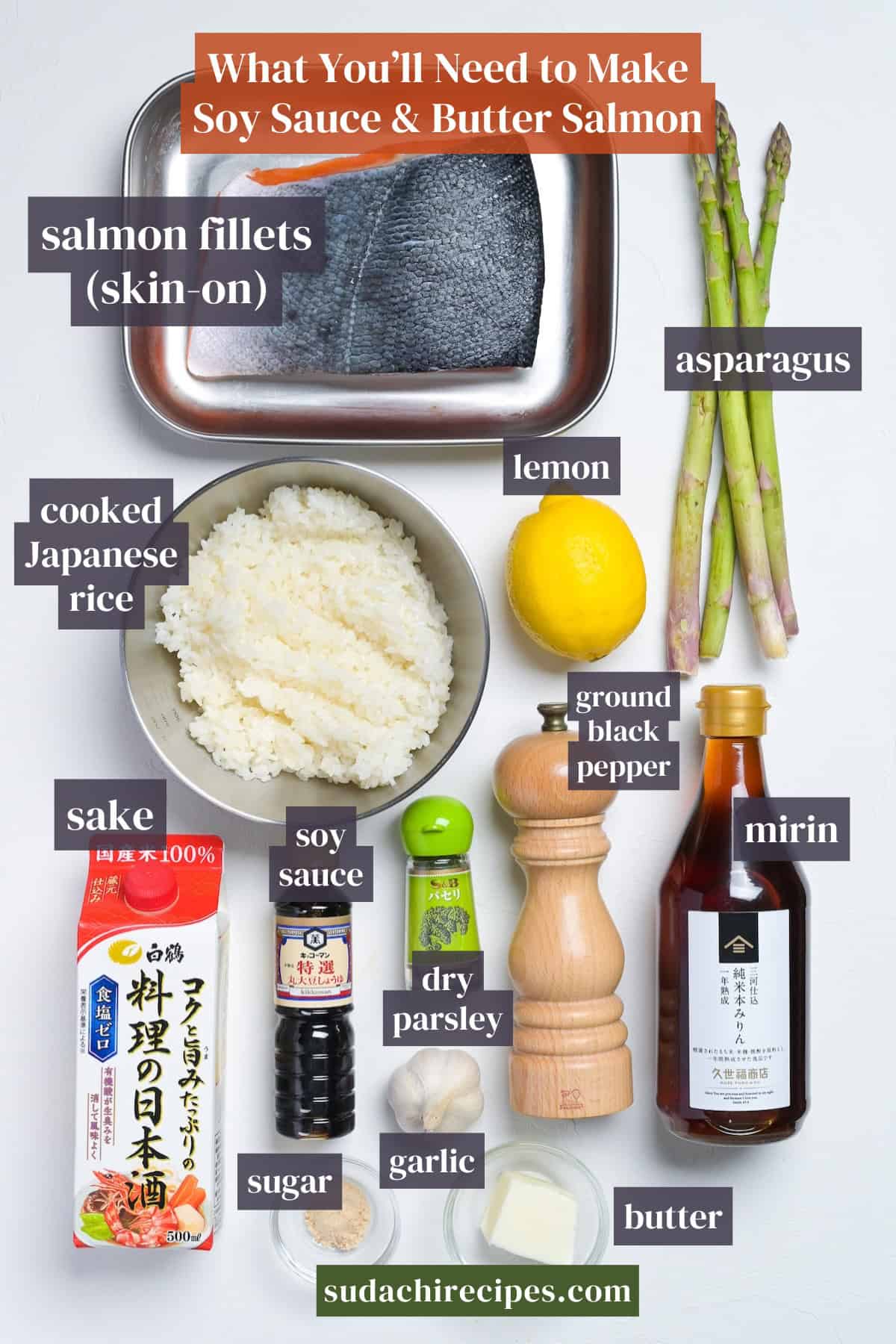 Ingredients needed to make soy sauce and butter salmon on a white background with labels. From top to bottom, left to right: salmon fillets, asparagus, cooked Japanese rice, lemon, sake, soy sauce, ground black pepper, mirin, dry parsley, sugar, garlic, butter