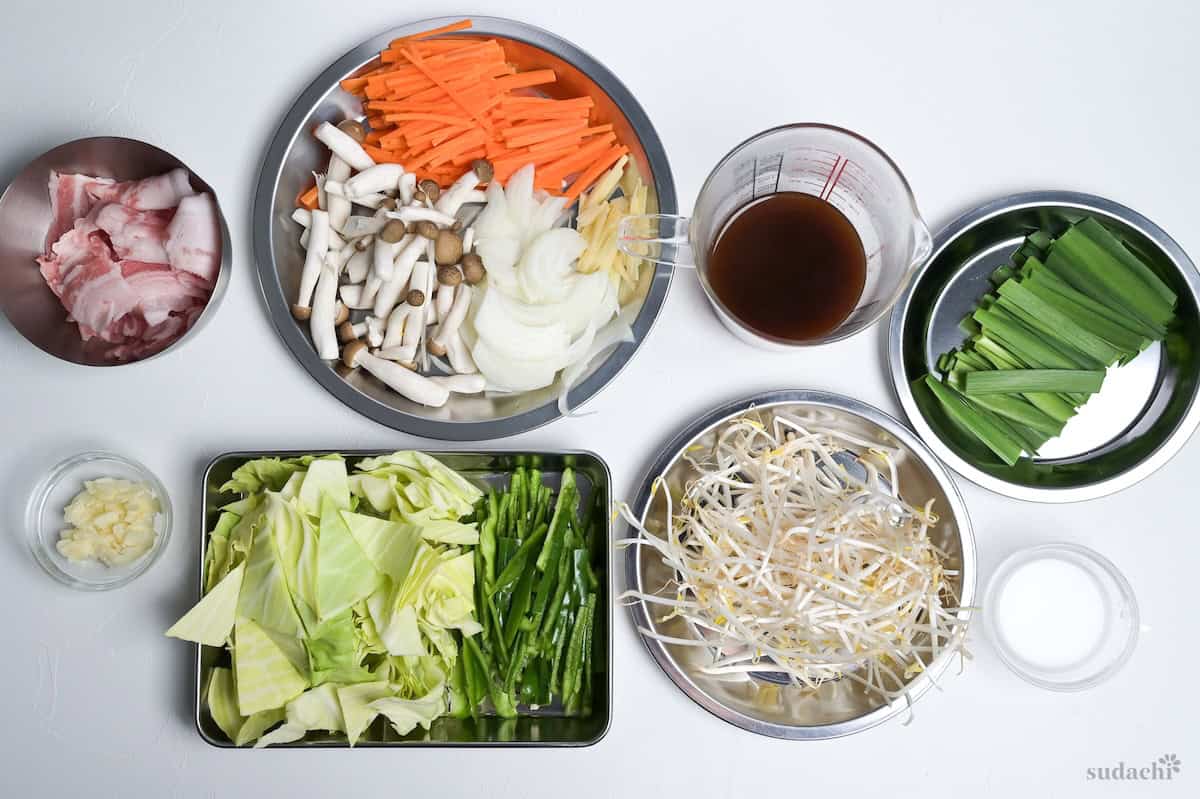Ingredients prepped and arranged on plates and in containers ready to cook Niku Yasai Itame.