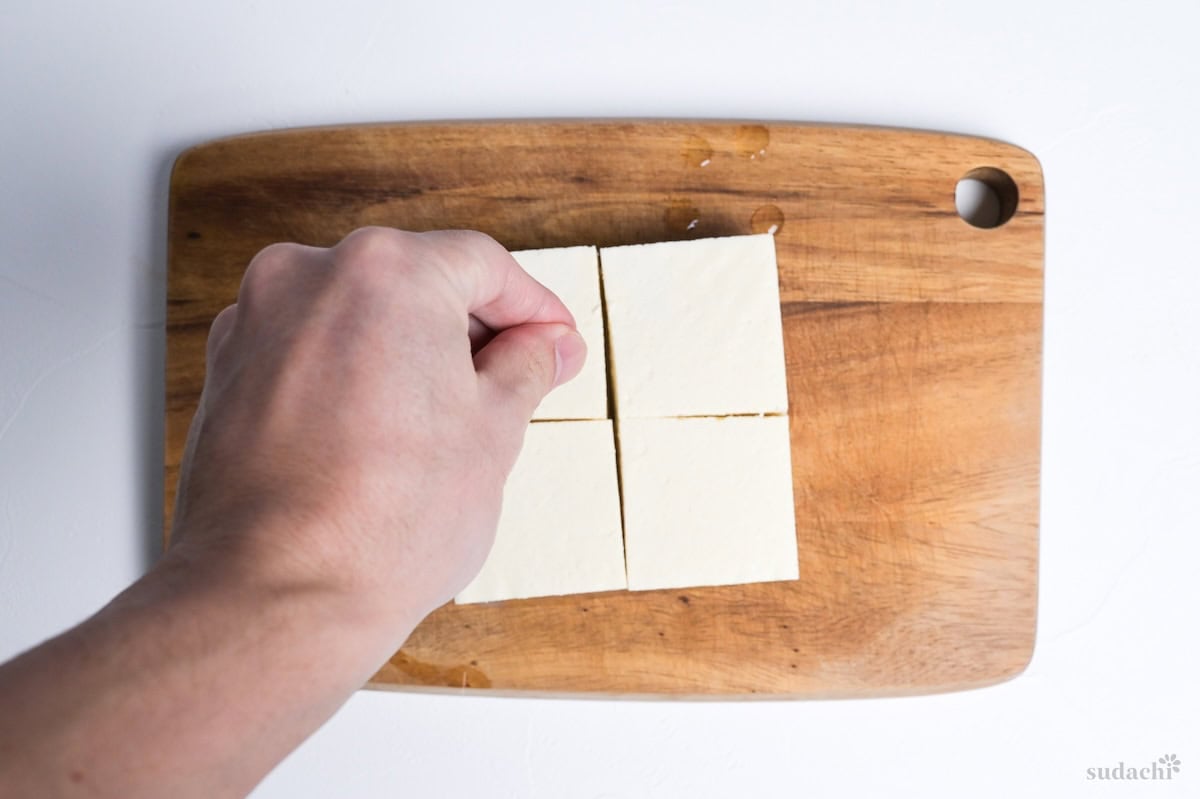 sprinkling firm tofu pieces with salt