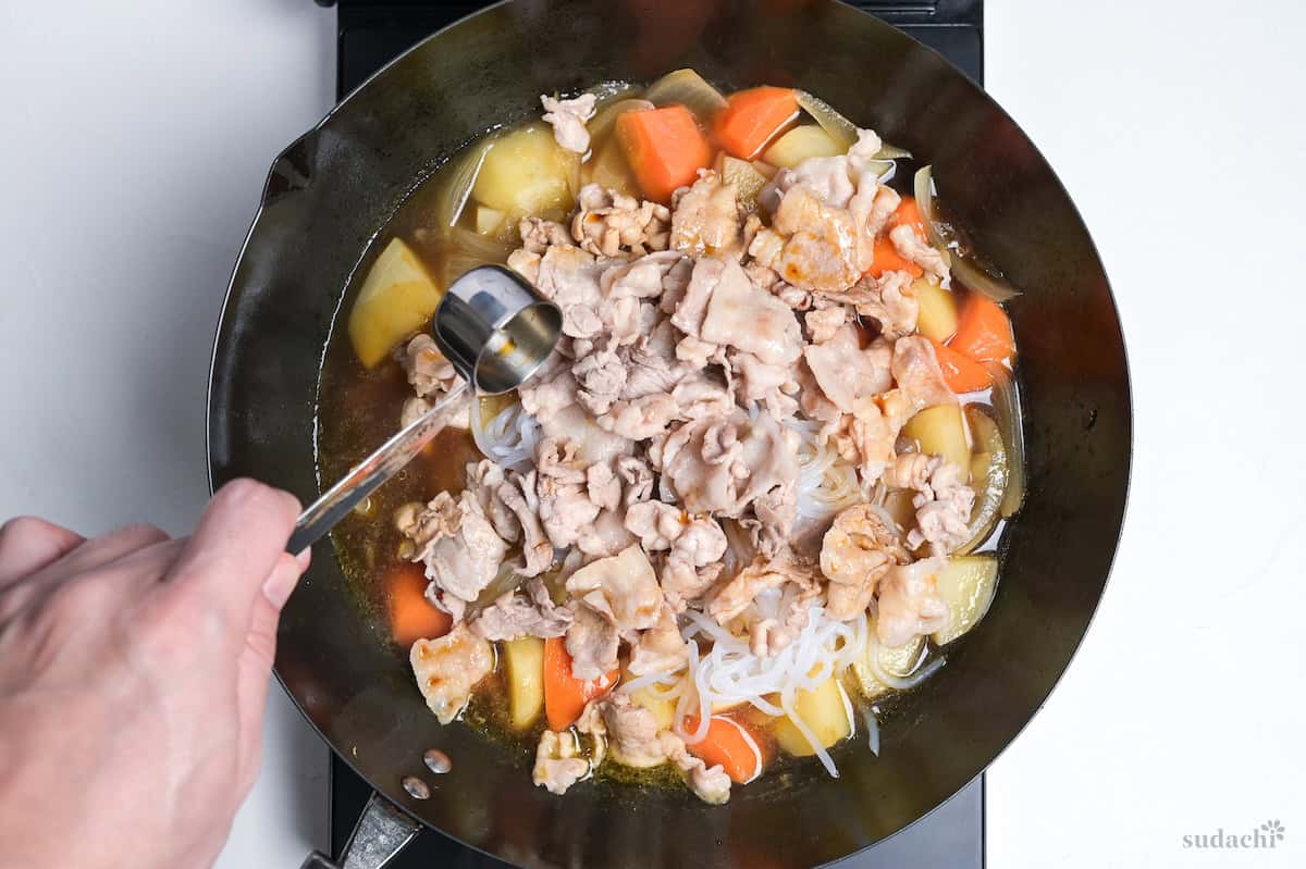 adding seared meat to nikujaga, and flavoring with soy sauce