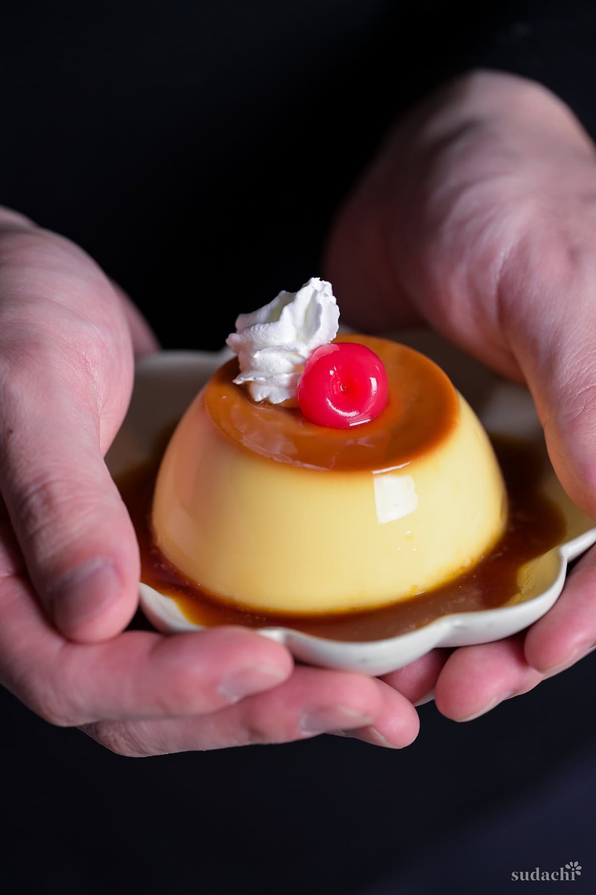 Japanese oven baked purin (yaki purin) topped with whipped cream and a maraschino cherry