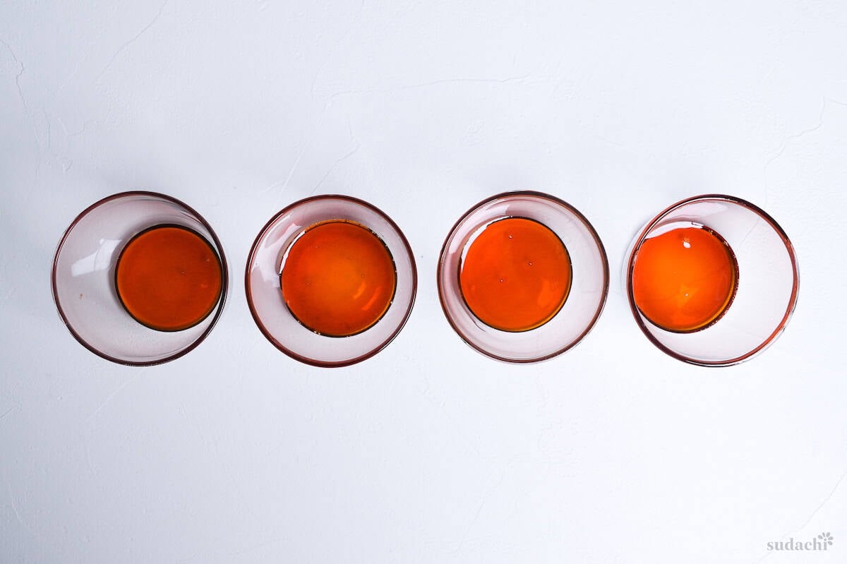 4 glass purin cups with a layer of homemade caramel at the bottom