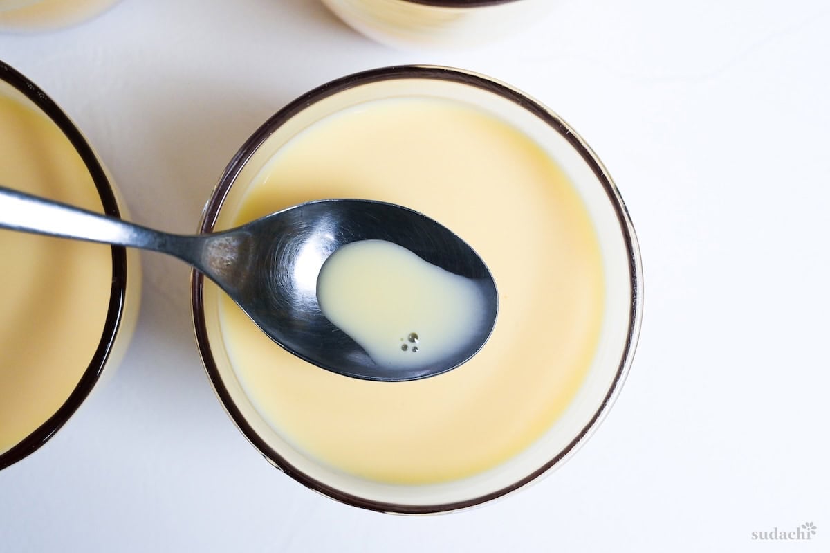 scooping bubbles out of purin before baking