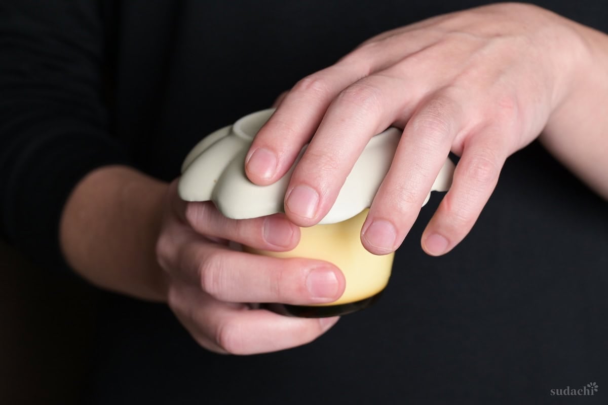 Yuto Omura holding a plate over purin in a glass purin cup