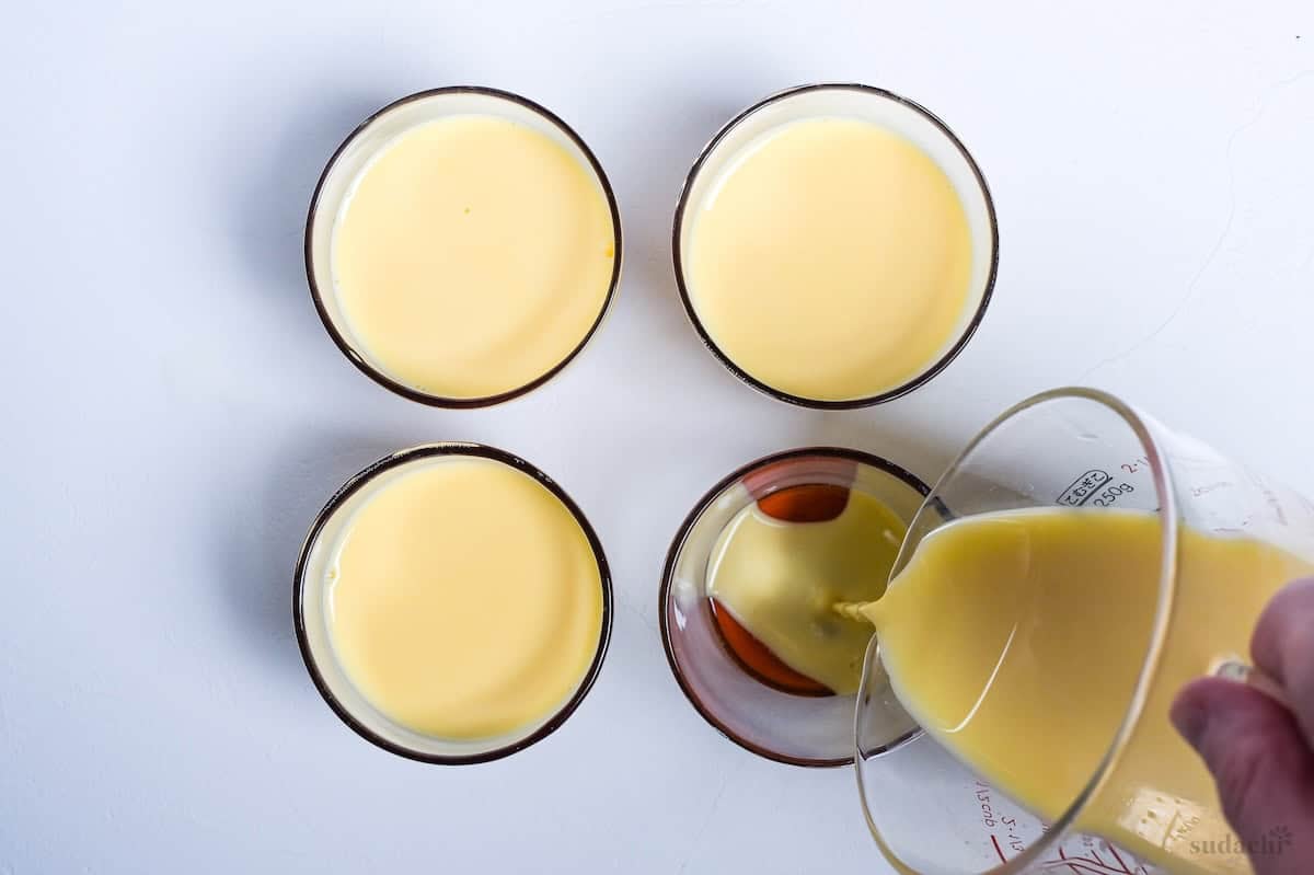 pouring custard purin mixture over caramel in glass purin cups