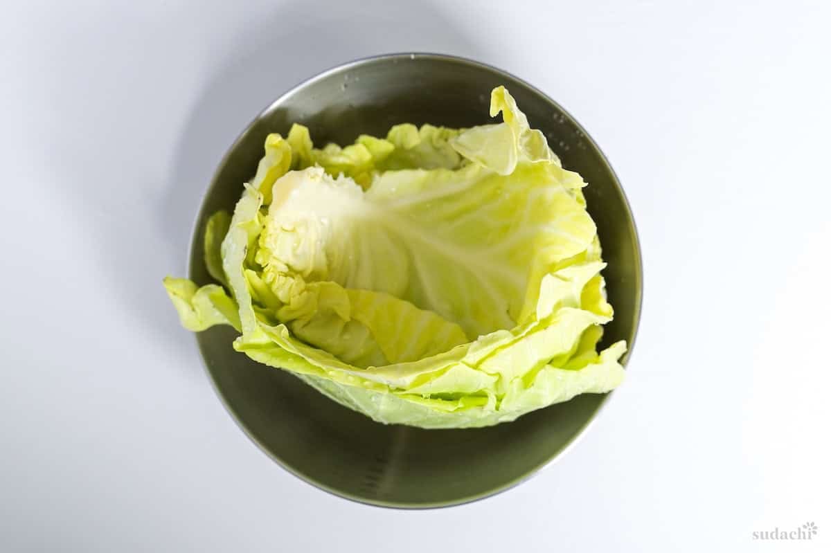 Green cabbage leaves in a bowl after cleaning with water