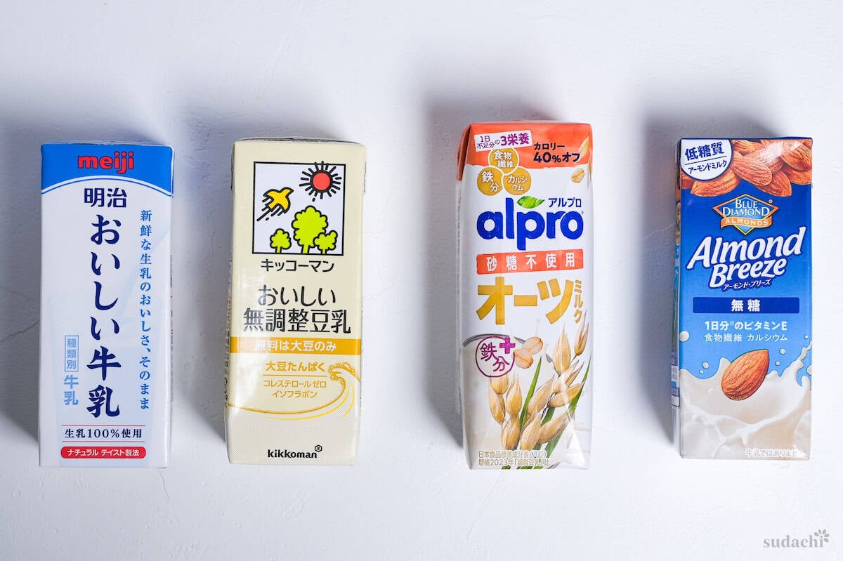 Four 200ml cartons of different kinds of milk used to make matcha latte. From left to right: whole cows milk (meiji), unsweetened soy milk (kikkoman), oats milk (alpro), almond milk (almond breeze).