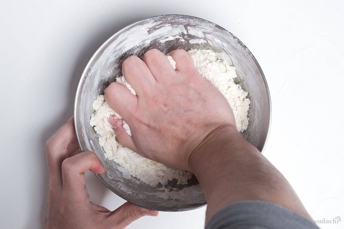 Kneading gyoza wrapper dough in a large mixing bowl