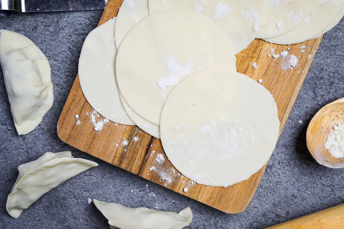 Homemade gyoza wrappers on a wooden cutting board