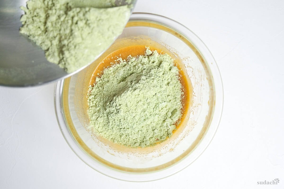 pouring dry ingredients into wet ingredients to make matcha blondies