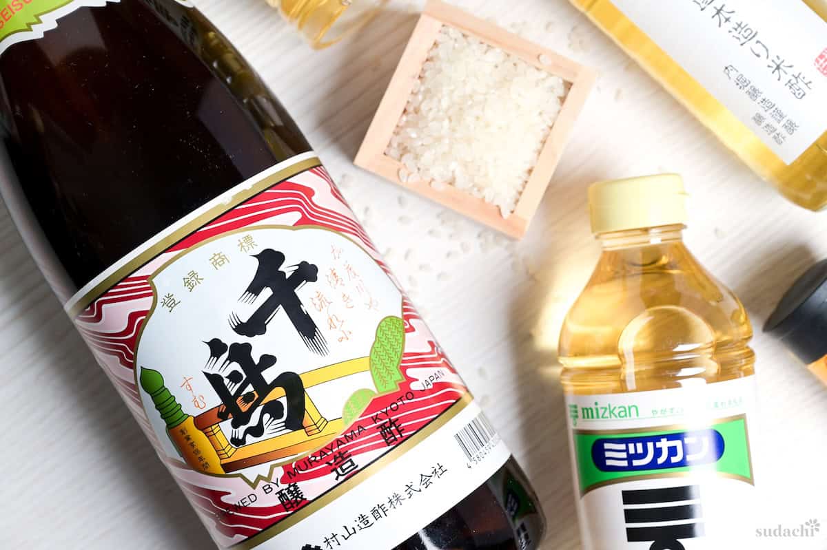 Bottles of Japanese rice vinegar (various brands) around a wooden masu filled with rice