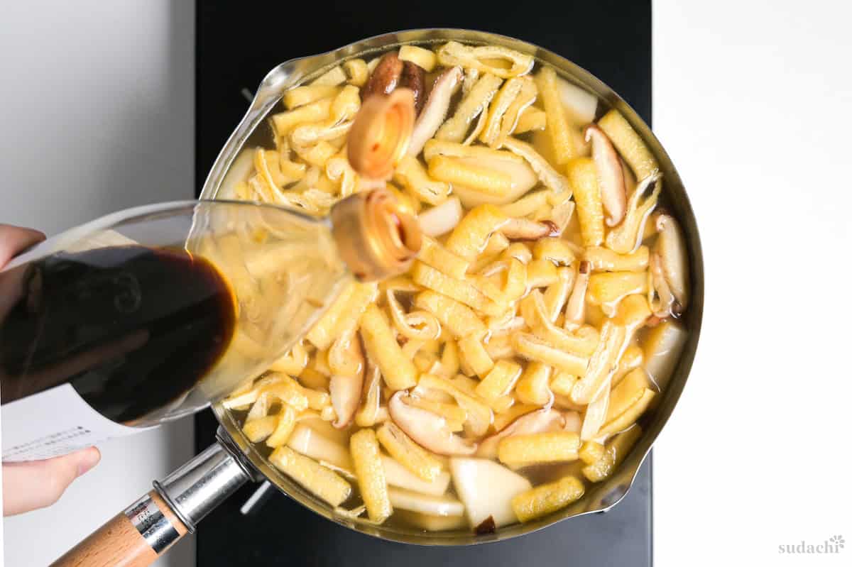 Pouring soy sauce into tonjiru.