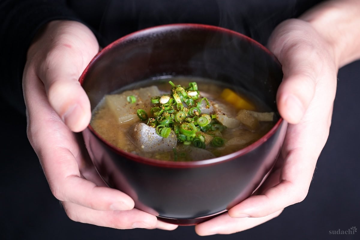Yuto Omura holding a steaming bowl of homemade tonjiru (pork miso soup)