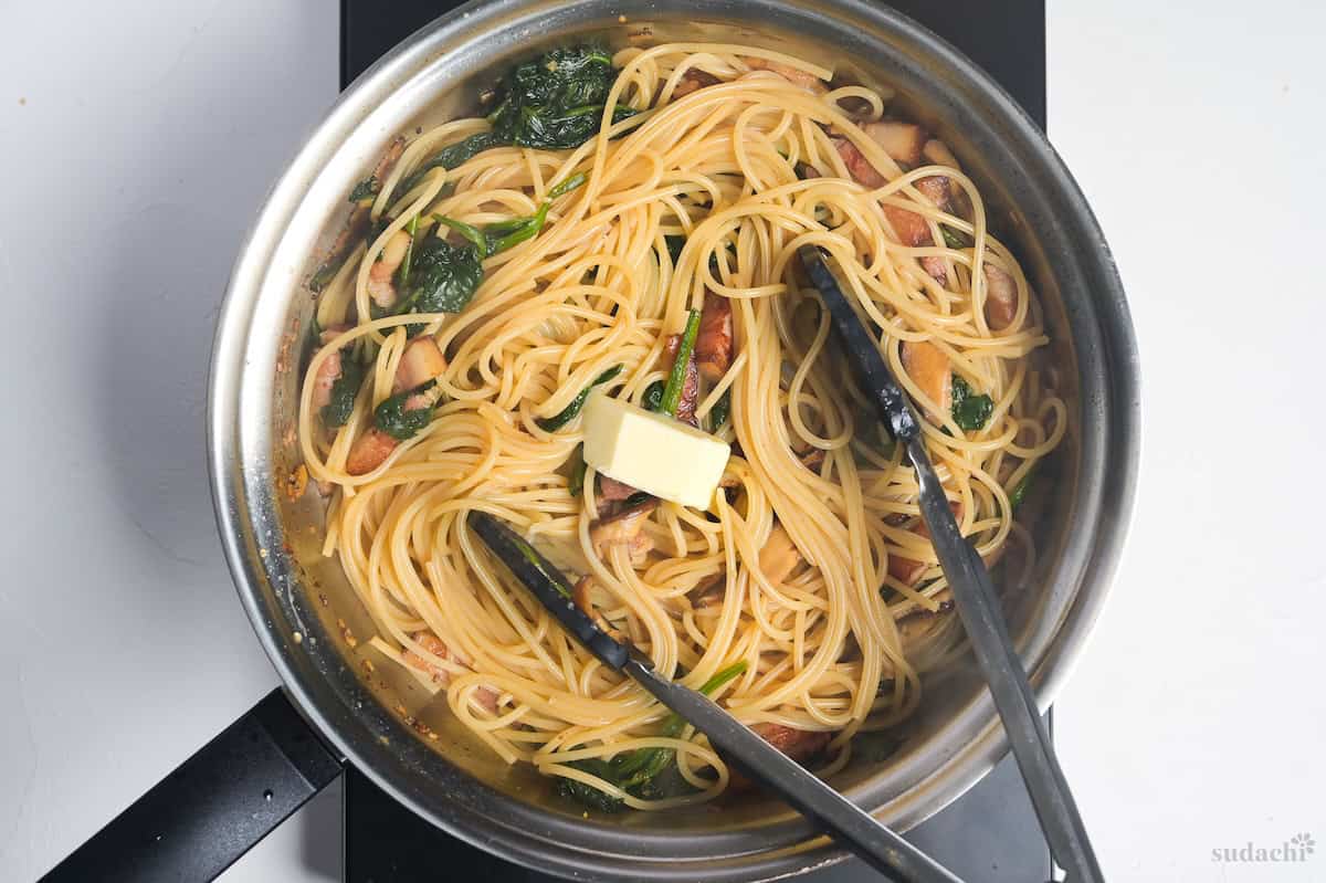 Melting butter into wafu pasta in a pan on the stove top