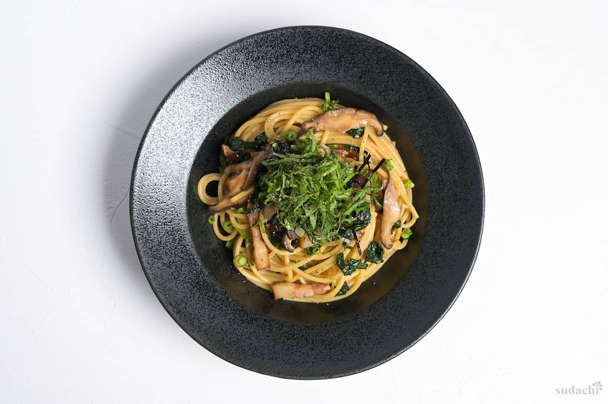 Wafu pasta topped with shredded shiso leaves and kizami nori served in a black pasta dish
