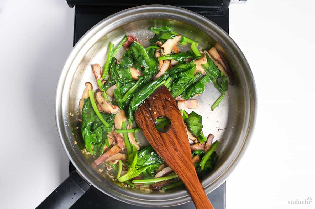 Spinach added to the pan with bacon and mushrooms to make wafu pasta