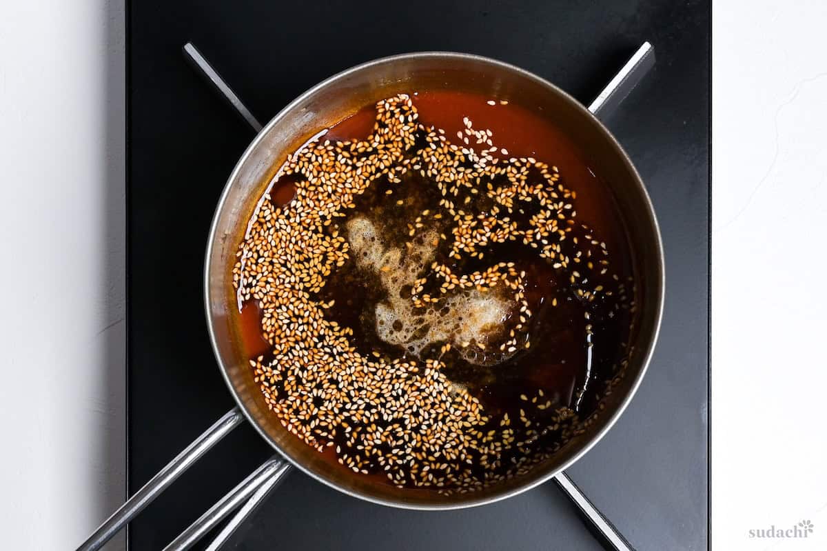 condiments and sesame seeds in a saucepan on the stove top to make yakiniku sauce