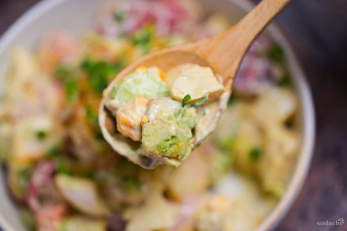 Japanese style avocado egg salad on a light wooden spoon