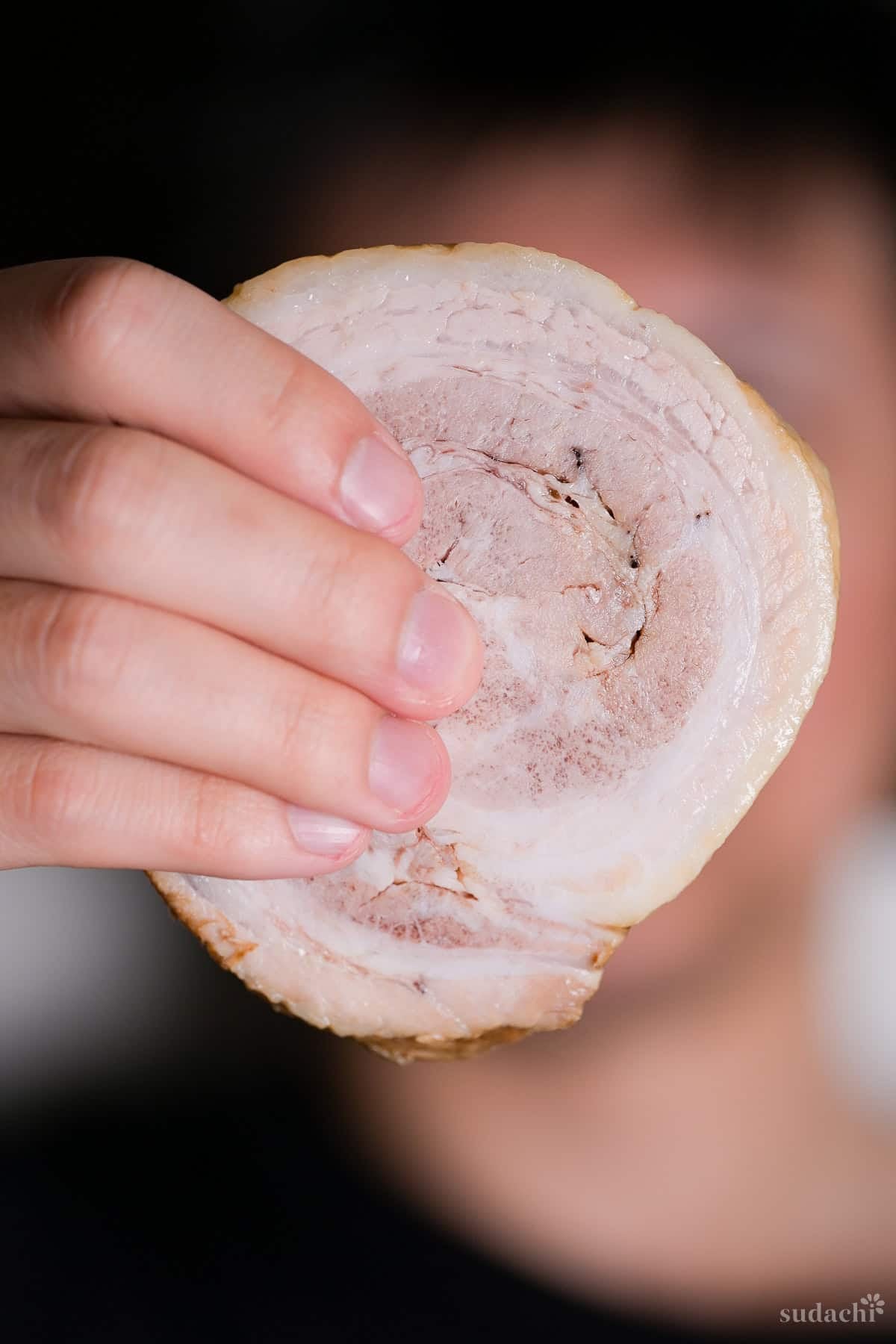 Yuto Omura holding up a piece of homemade pork chashu