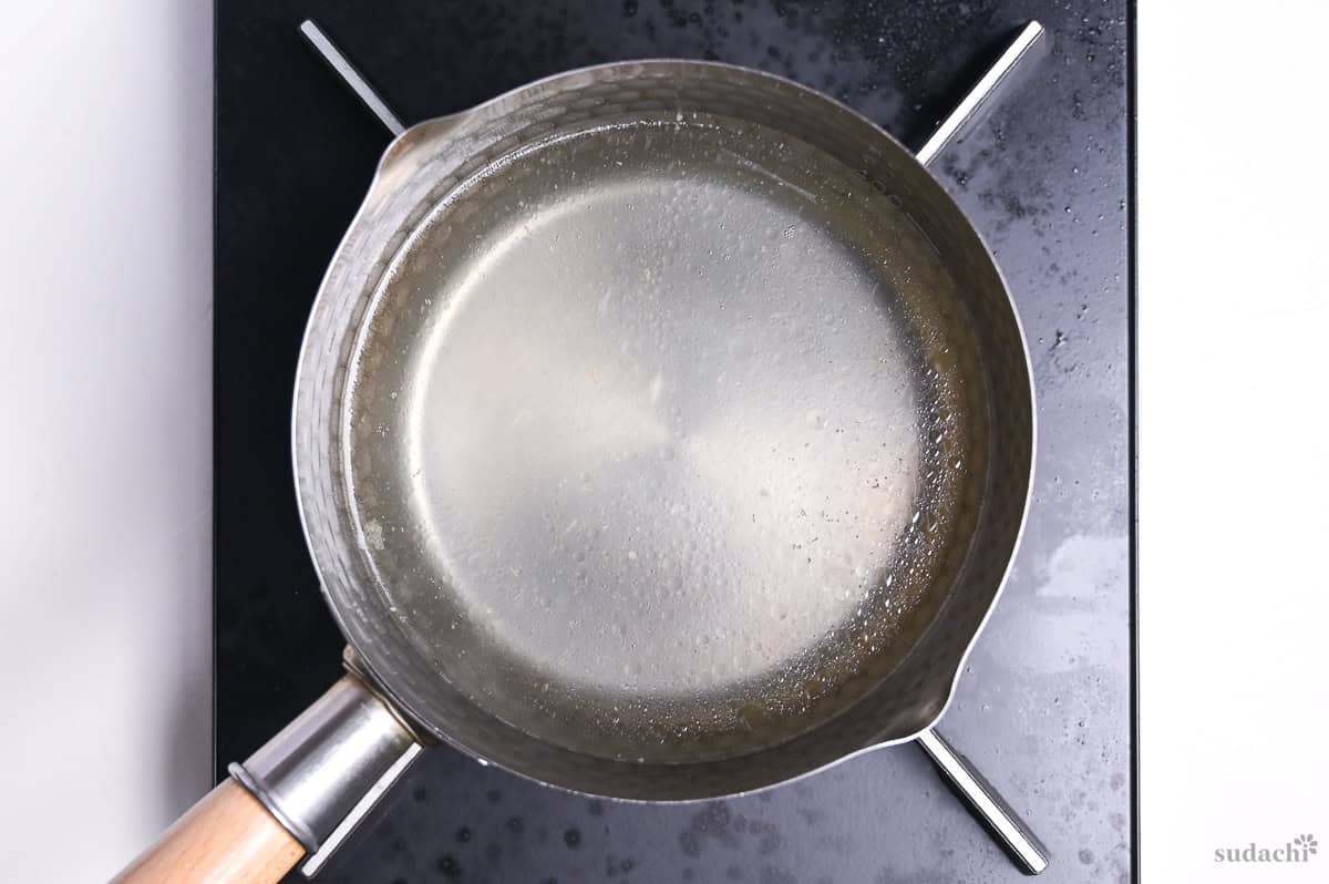 pork broth simmering in a pot on the stove