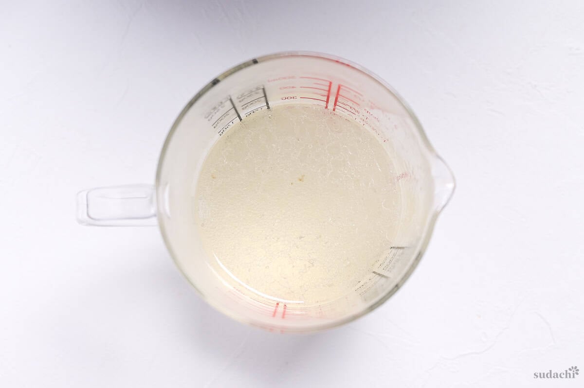 pork stock reserved in a glass jug to make marinade for chashu