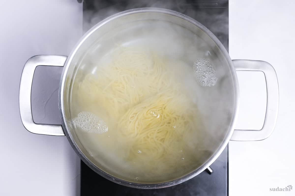 boiling ramen noodles in a pot of water on the stove top