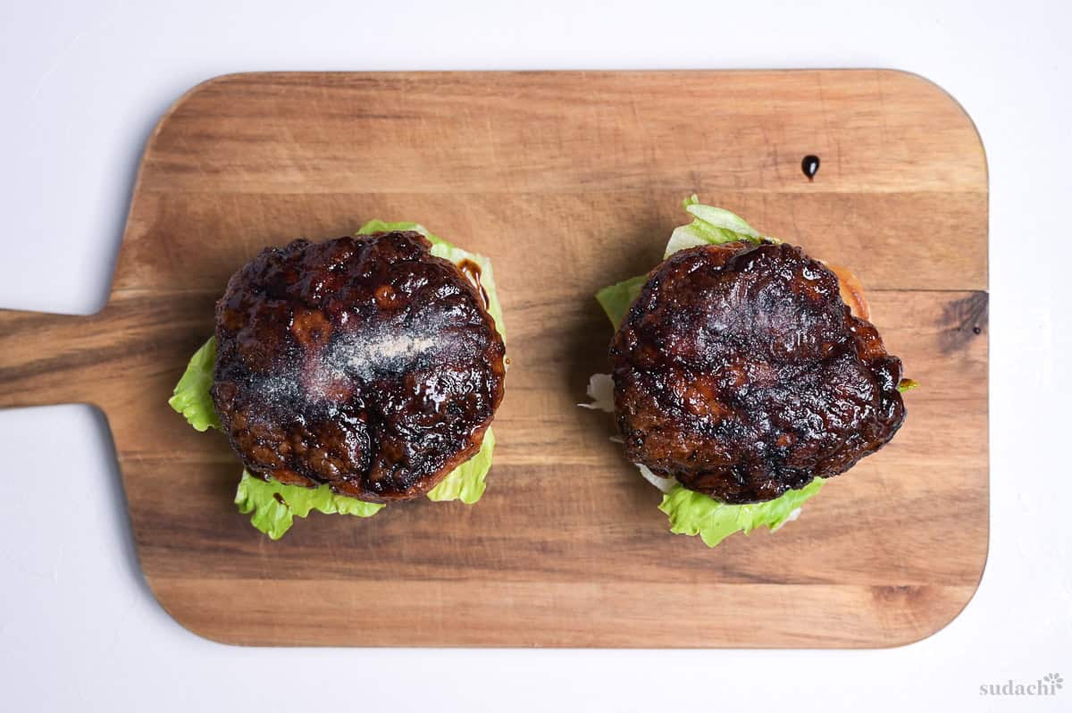 burger bun bases topped with lettuce and teriyaki pork patties