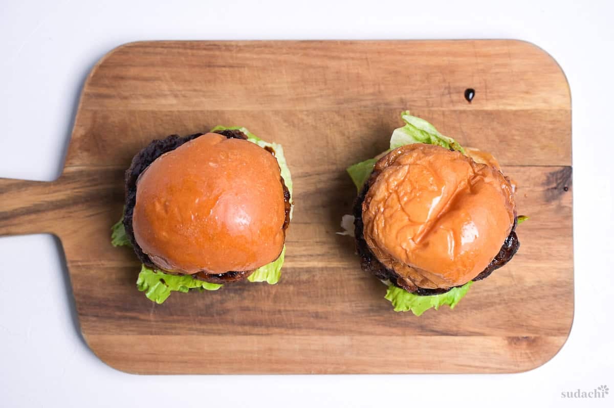 pork teriyaki burgers with top bun on a wooden cutting board