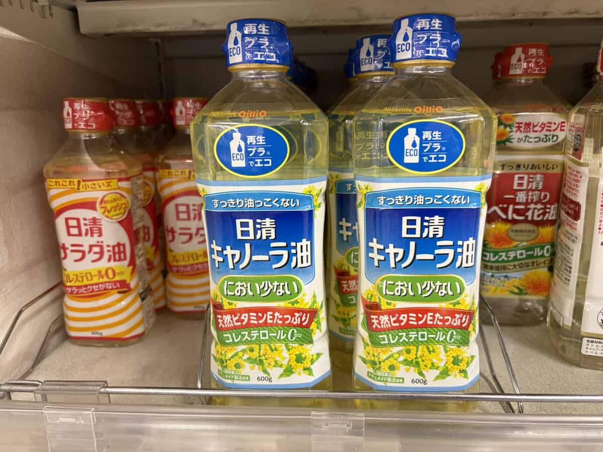 Bottles of Nisshin Oillio canola oil on a Japanese supermarket shelf
