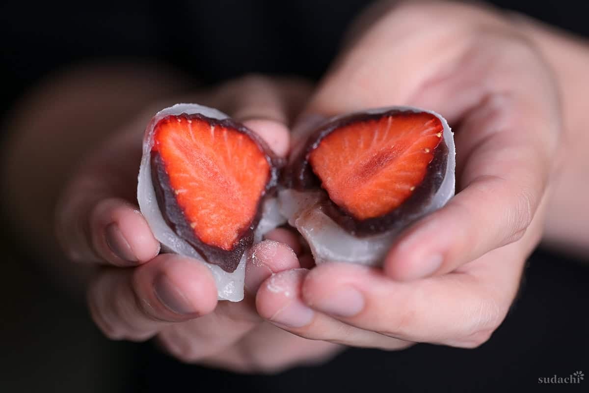 Yuto Omura holding two halves of homemade ichigo daifuku (strawberry mochi)