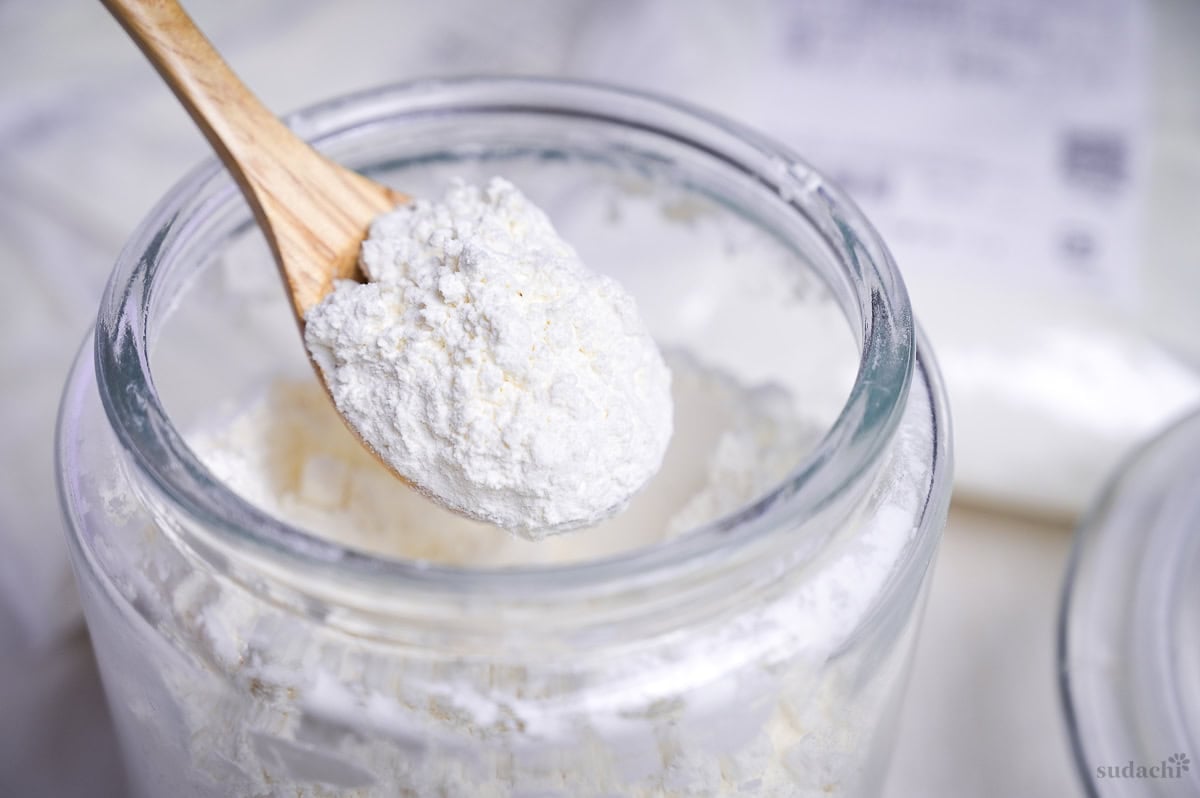 A scoop of low protein flour on a wooden spoon
