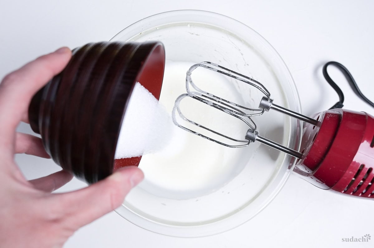 adding the rest of the sugar to meringue to make Japanese soufflé cheesecake