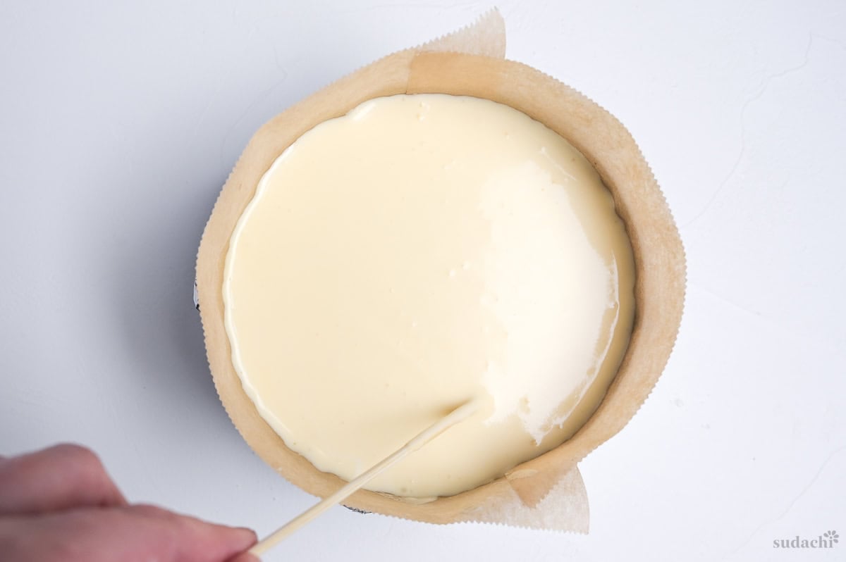 drawing crosses in soufflé cheesecake batter to remove bubbles