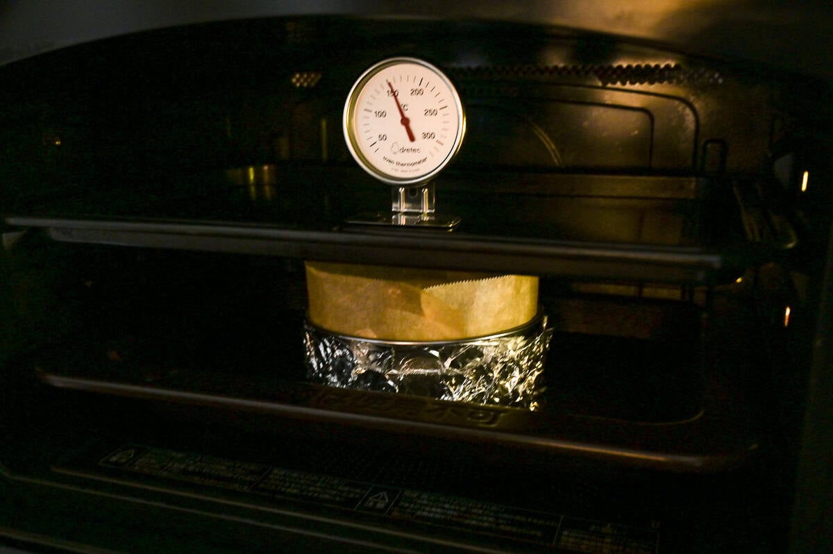 souffle cheesecake in oven with baking tray above it